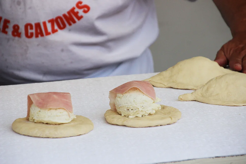 Making cheese and ham calzone for the festival